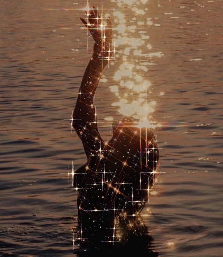 Woman rising from the water, sparkling in the light
