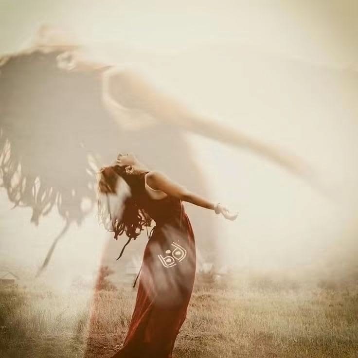 Woman with arms open wide, leaning back in a misty field