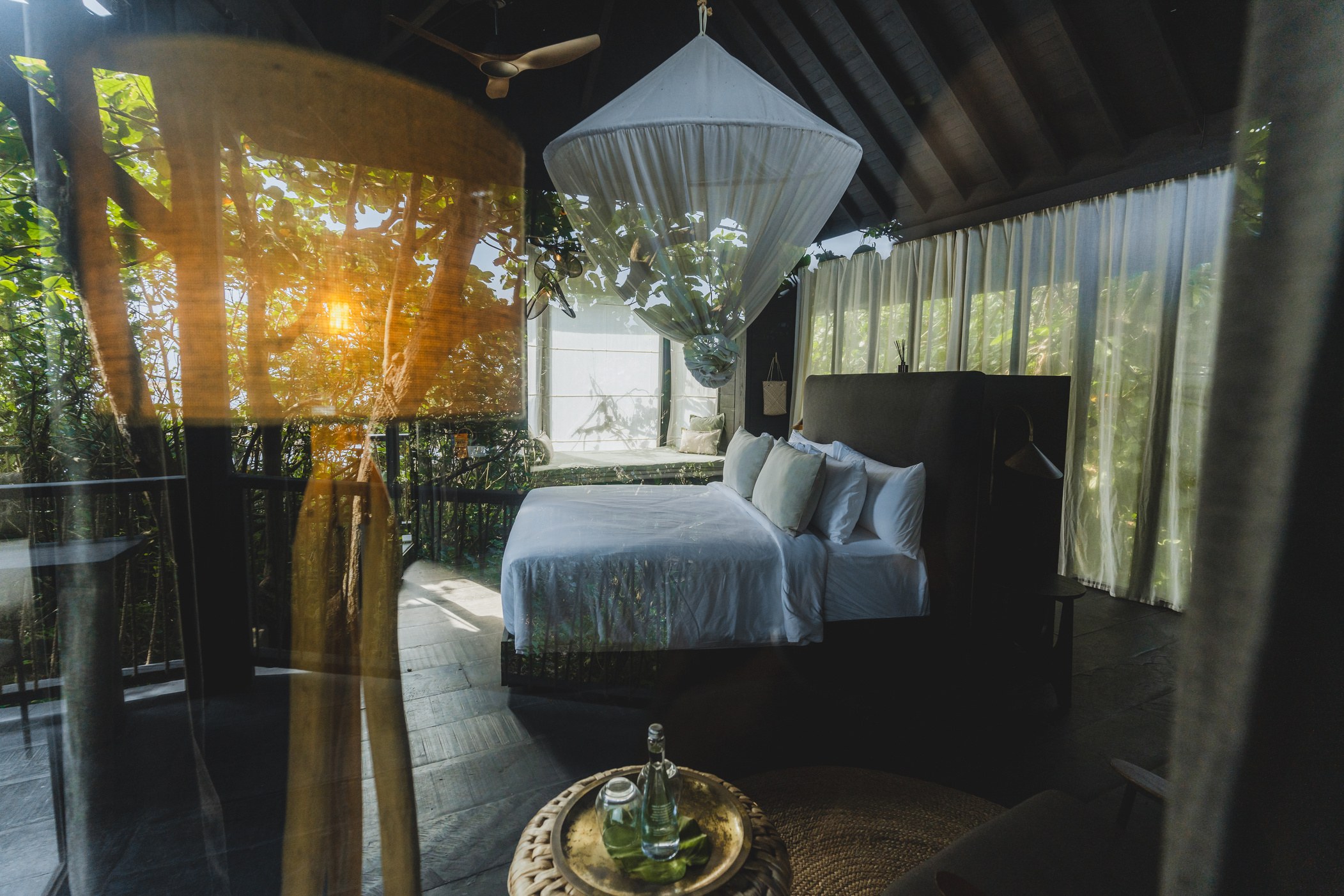 Treehouse bedroom with mosquito net and forest views